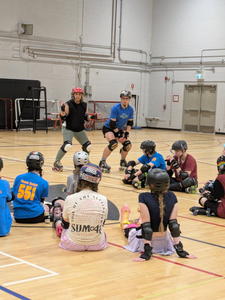 Coaches talking to Jr Roller Derby players.