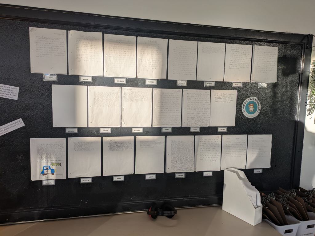 A classroom bulletin board proudly displaying various student handwriting and composition projects.