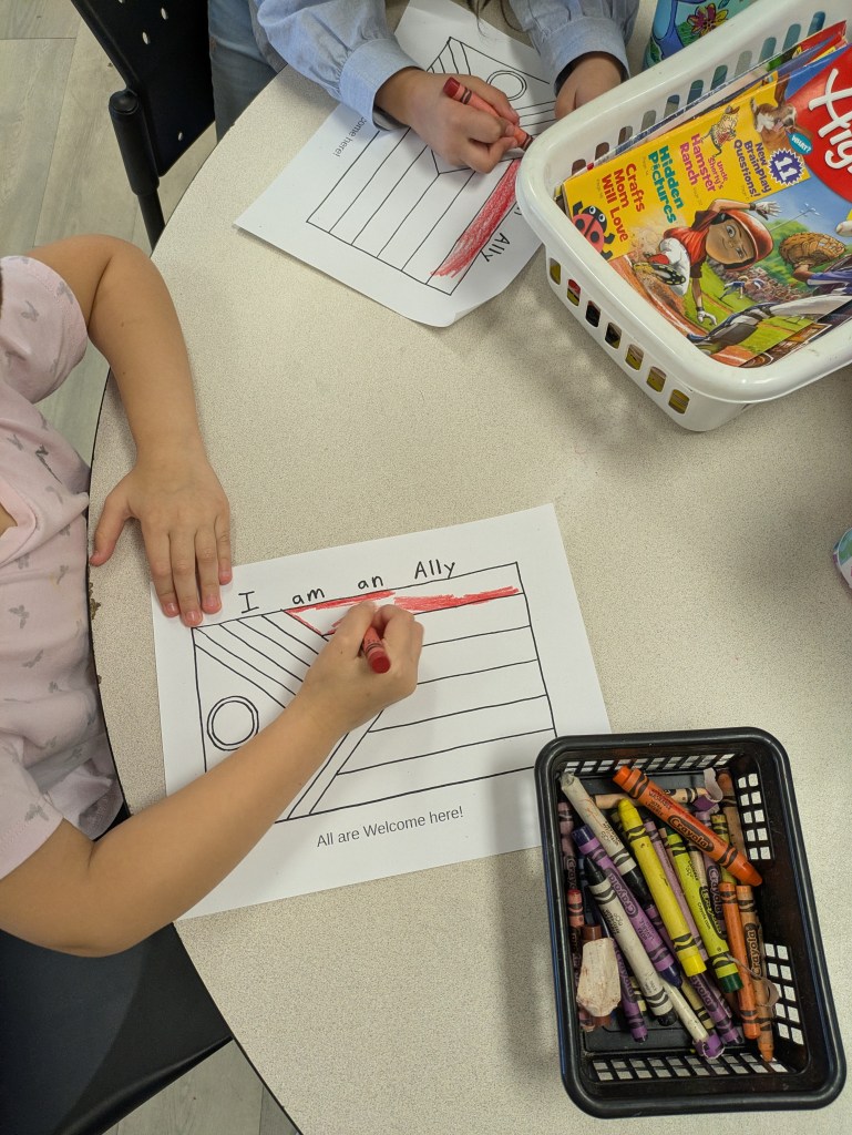 Student colouring a 2SLGBTQ+ Pride flag