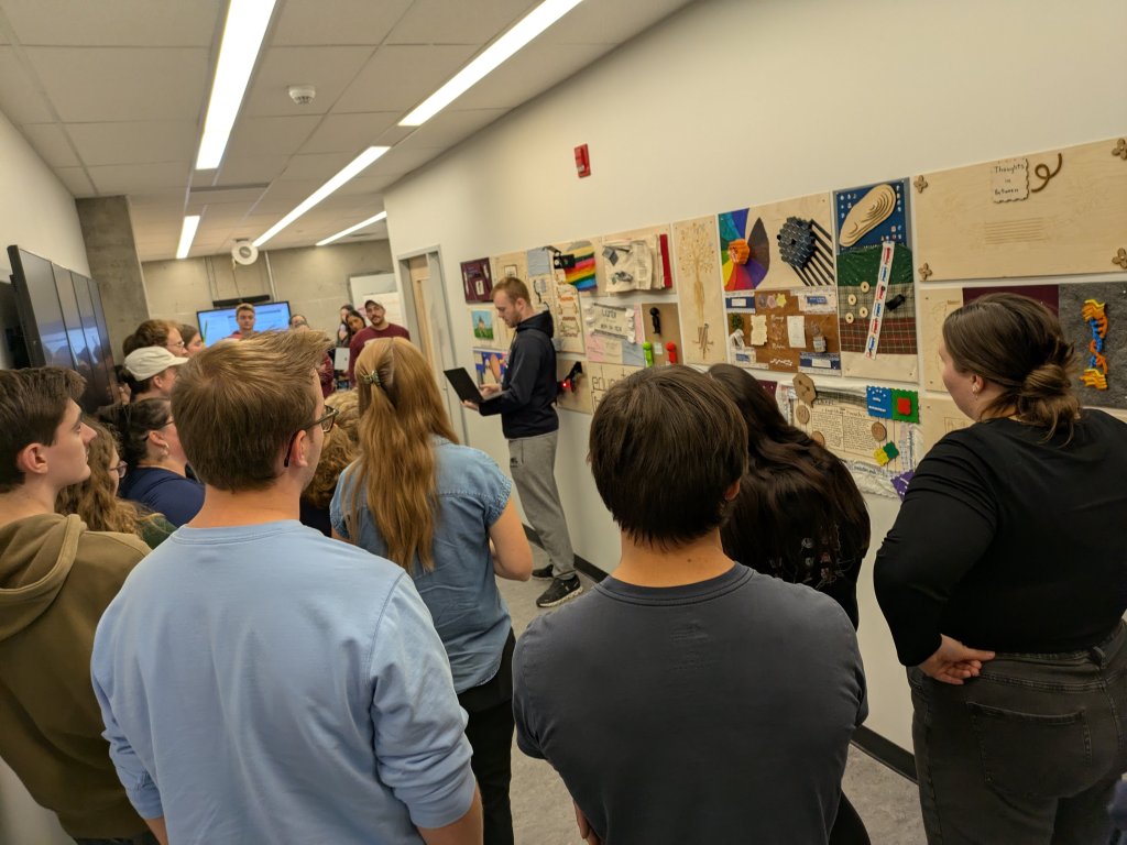 Teachers standing in a university Makerspace presenting a piece of technology-enhanced art.